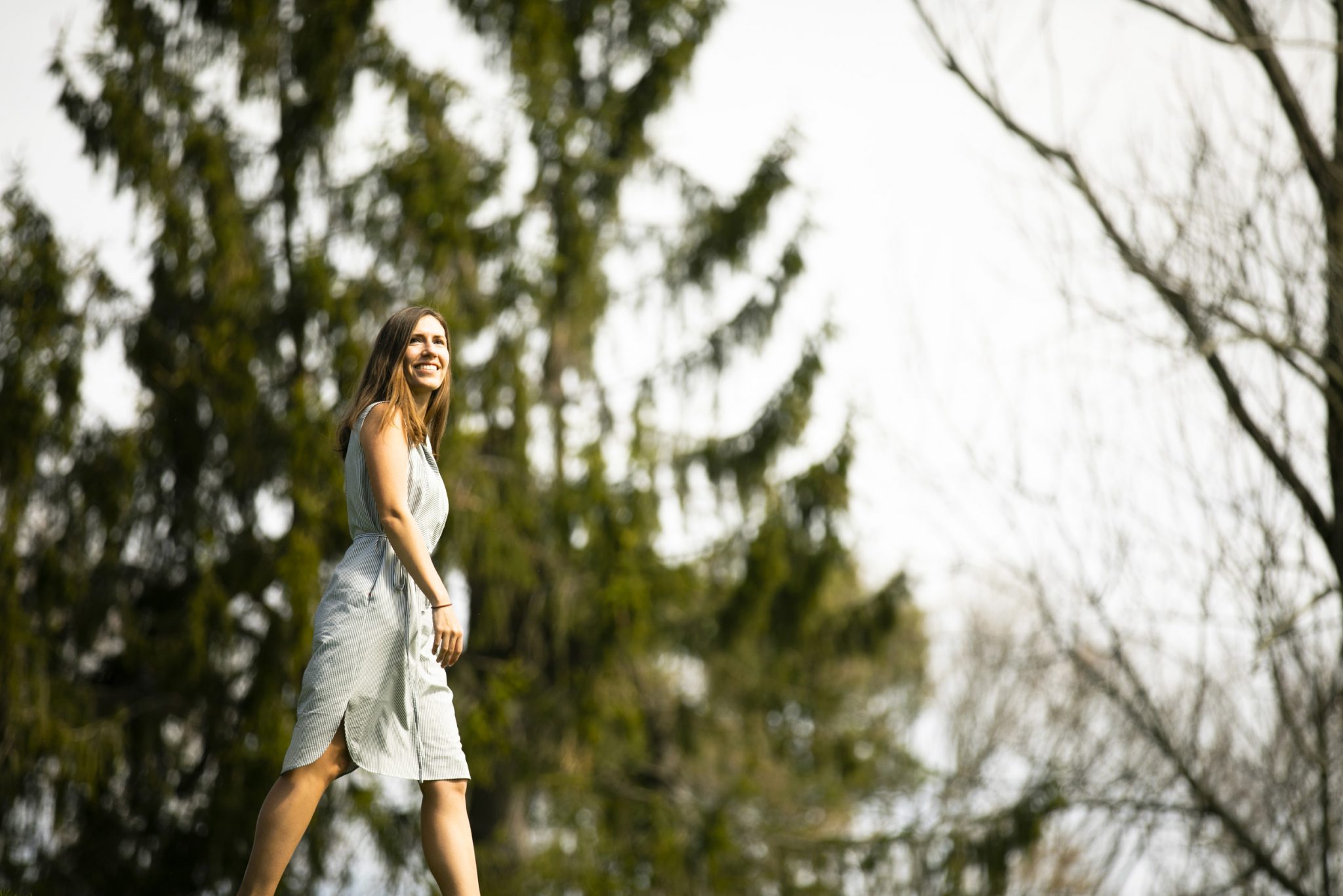 A photo of Lucy Shaw walking with blurred trees in the background