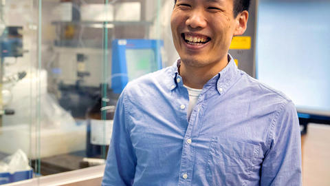 Brian Liau stands in his lab, smiling broadly