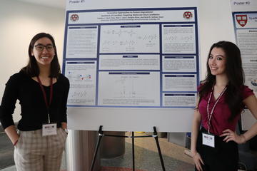 Two undergraduates stand in front of a research poster