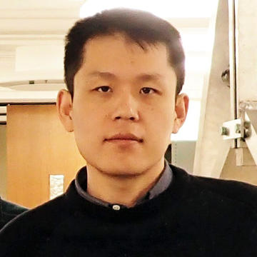 A headshot of Suyang Xu wearing a black sweater, looking directly at the camera