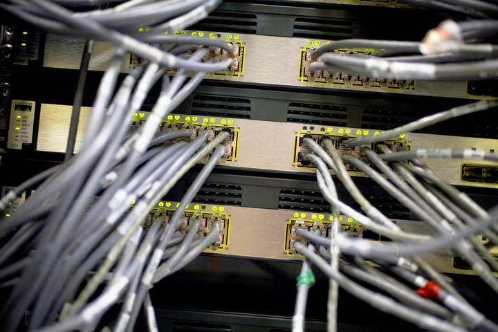 Thick and many wires snake through racks of computer storage in Harvard's Information Services Center