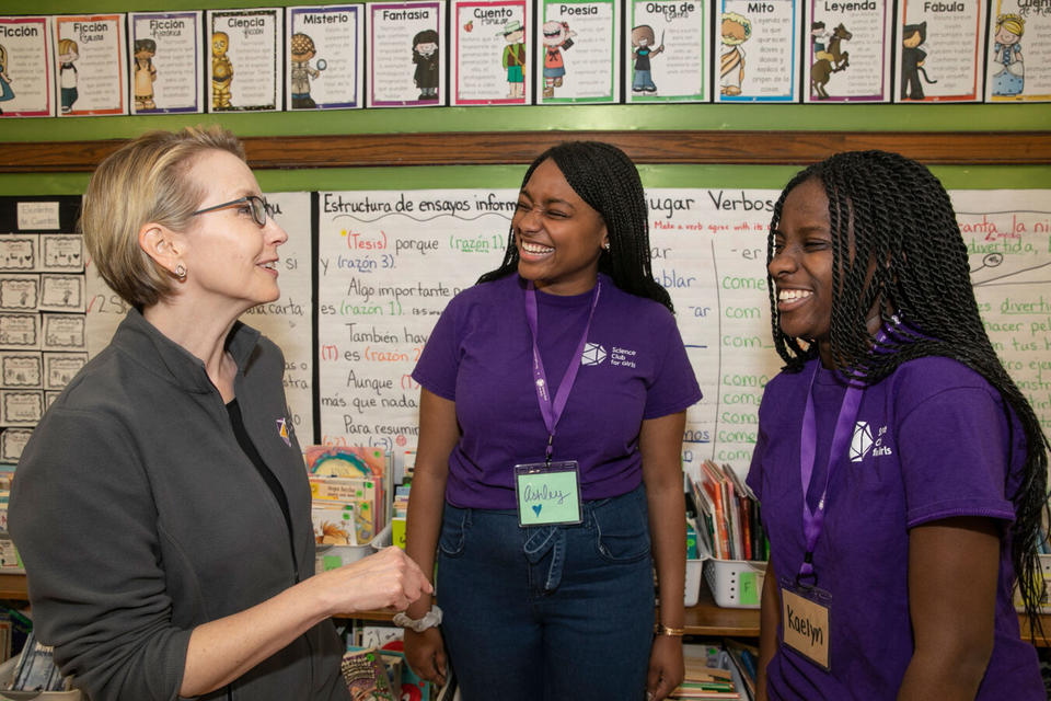 A photo of Ashley Cooper and Kaelyn Brown talking to Science Club for Girls Executive Director Bonnie Bertolaet