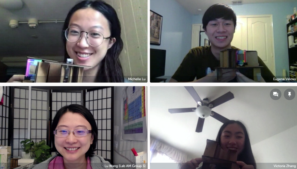 A screenshot of a Zoom conference with students holding up their homemade spectrometers