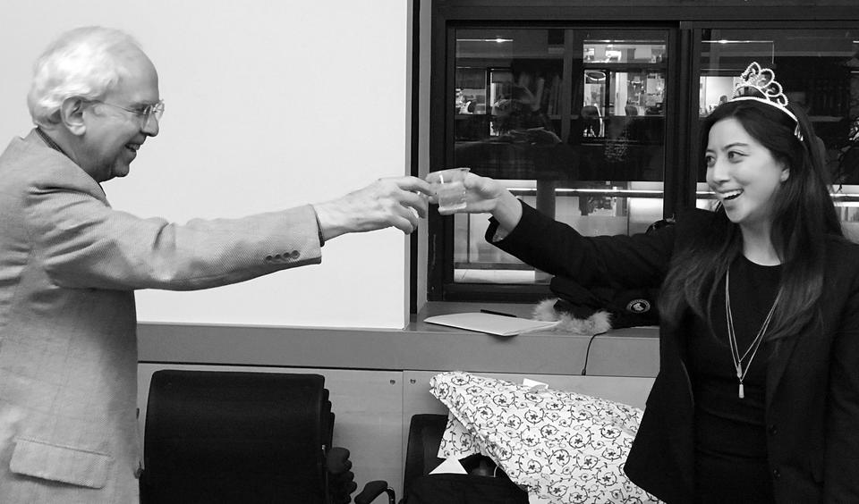 A photo of Christina and Roy clinking plastic glasses of champagne